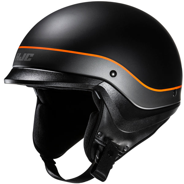 822150503 | A black motorcycle helmet with a matte finish, featuring a sleek silver stripe along the side with an orange accent line running parallel, and the brand logo 'HJC' in gray on the side. The helmet has a smooth, rounded shape with a slightly extended visor area, and a black interior lining visible at the bottom. The background is plain white, emphasizing the helmet's modern, aerodynamic design, with soft lighting that highlights its contours and matte texture. | Available at BTO Sports