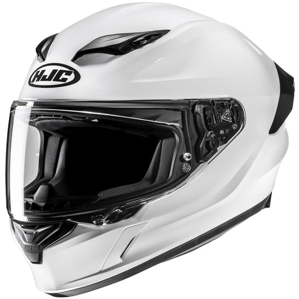 810017703 | A white full-face motorcycle helmet with a black visor, featuring a sleek aerodynamic design, black vents on the top, and a black rear section, set against a plain white background. The helmet has a prominent black and white HJC logo on the front, with detailed internal padding visible through the open visor, and subtle shadows indicating a well-lit, professional studio setting. | Available at BTO Sports