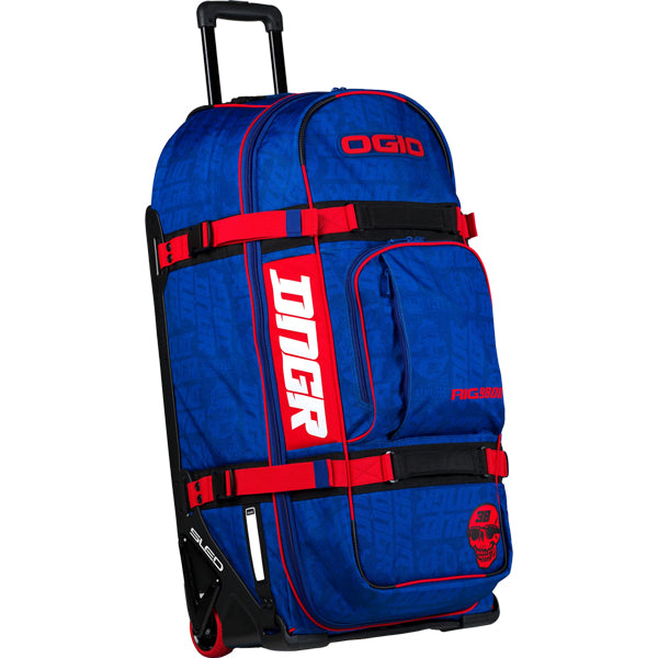 Front three-quarter view of the OGIO RIG 9800 DNGR X gear bag in bright blue with tonal DNGR graphics, red compression straps, extended telescoping handle, and red wheels. SKU 80100024 | Available at BTO Sports