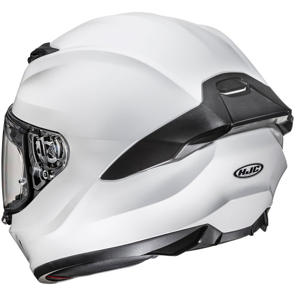 810017703 | A white full-face motorcycle helmet with black accents, featuring a clear visor, aerodynamic design, and a matte finish, set against a plain white background. The helmet has a black vent on top, a black chin guard, and an HJC logo on the side, with lighting highlighting its smooth curves and reflective visor. | Available at BTO Sports