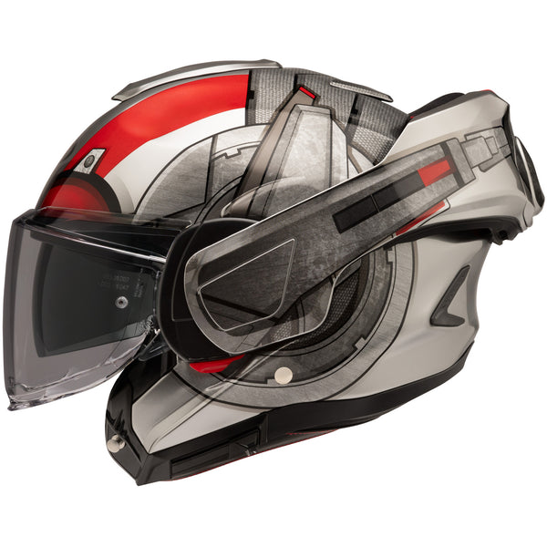 A modern motorcycle helmet with a sleek, aerodynamic design featuring a primarily white and gray color scheme accented with red and black details. The helmet has a clear visor, a textured surface on the top and sides, and a streamlined shape that emphasizes speed and safety. It is positioned at a slight angle, showcasing the front and side views, with a plain white background. The lighting highlights the glossy finish and intricate surface textures, creating subtle reflections and shadows that enhance the h