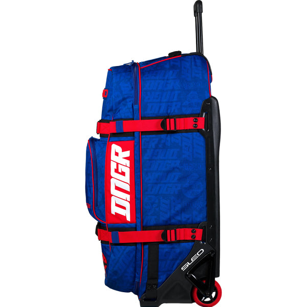Opposite side profile of the blue OGIO RIG 9800 DNGR X showcasing the DNGR logo panel, red compression straps, and SLED structural base with red wheel. SKU 80100024 | Available at BTO Sports