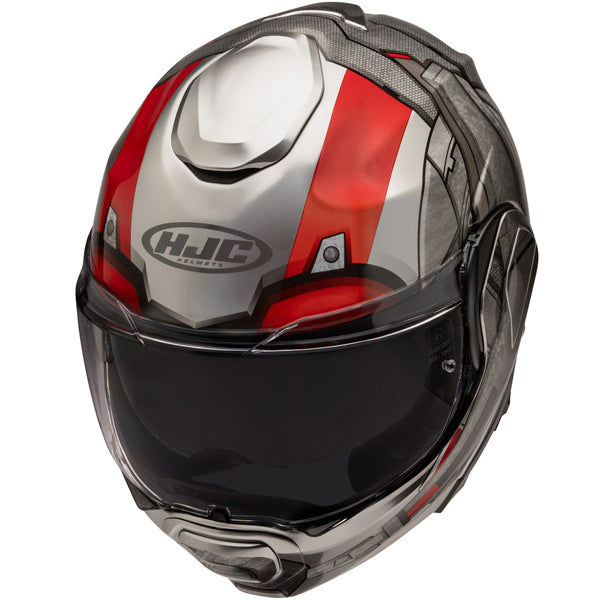 A full-face motorcycle helmet with a sleek, aerodynamic design featuring a glossy black visor, predominantly white with bold red and gray accents, and the HJC Helmets logo prominently displayed on the front. The helmet has a textured carbon fiber top and sides, with vents on the top and chin area for airflow, and a clear visor that is slightly raised. The background is plain white, emphasizing the helmet's modern, high-performance style, suitable for a professional or enthusiast rider.