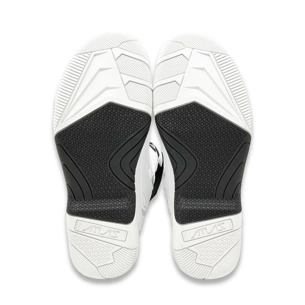 A view of the soles of a pair of white Atlas Traction Boots (SKU: A50000007), highlighting the bonded dual compound outsole with a steel shank.