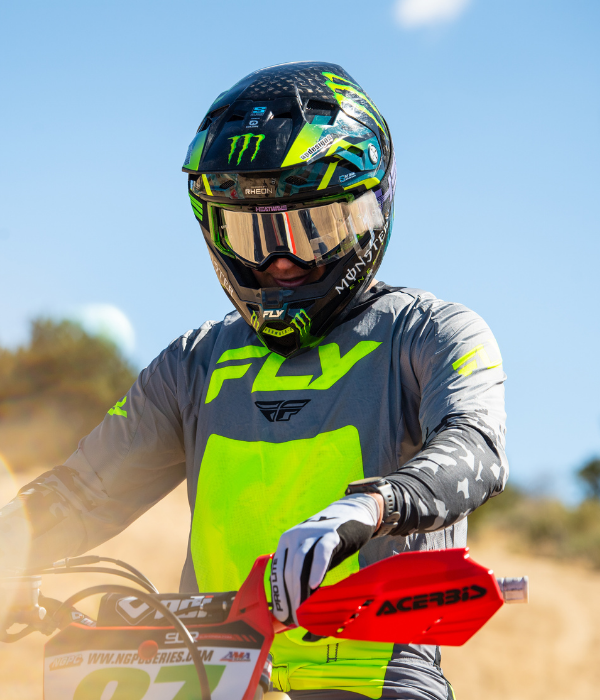 Rider wearing FLY Racing gray and fluorescent yellow motocross gear with helmet and goggles while sitting on a dirt bike. collection