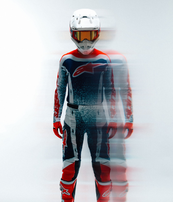Rider wearing Alpinestars Supertech motocross gear and helmet with creative motion blur effect on a clean studio background. collection