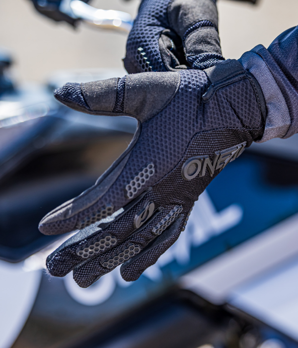Close-up of black O'Neal motocross glove showing silicone grip, breathable mesh construction, and flexible fit. collection