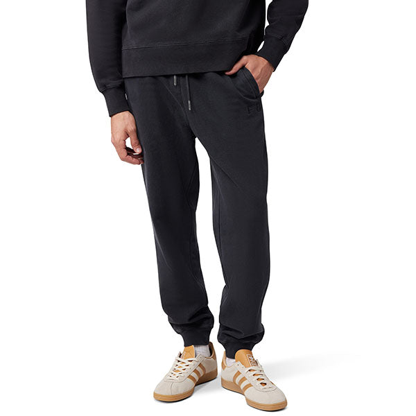Side view of model wearing Wordmark Joggers in Black, SKU 33146-001, highlighting fleece texture