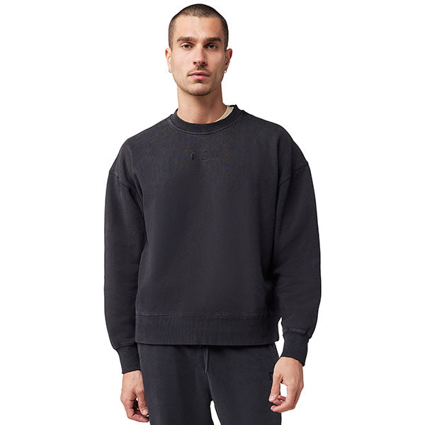 Side view of model wearing Wordmark Crew Pullover in Black, SKU 33142-001, highlighting ribbed cuffs and hem