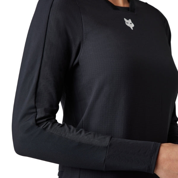 Fox Racing Defend Thermal Jersey (MTB) (Womens) in Black, modeled front three-quarter view, with the crew neck, long sleeves, contrasting shoulder and arm graphics, and extended rear hem on a rider. Available options—Color: Brown Sugar, Black; Size: XS, SM, MD, LG, XL. SKU 33787-001-M. UPC 191972931529.