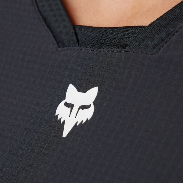 Fox Racing Defend Thermal Jersey (MTB) (Womens) in Black, close-up of the chest and shoulder panels, with the printed Fox artwork, mesh-knit texture, reinforced seam lines, and shaped cuff or hem. Available options—Color: Brown Sugar, Black; Size: XS, SM, MD, LG, XL. SKU 33787-001-L. UPC 191972931536.