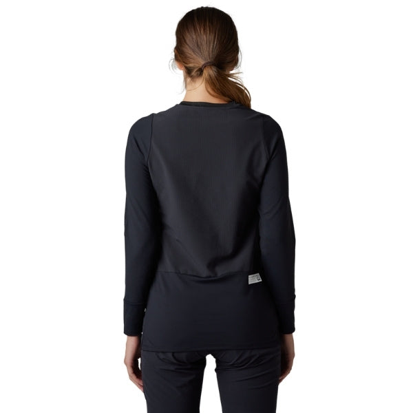 Fox Racing Defend Thermal Jersey (MTB) (Womens) in Black, full modeled rear view, with the back graphic, shoulder panels, long sleeves, and drop-tail hem. Available options—Color: Brown Sugar, Black; Size: XS, SM, MD, LG, XL.