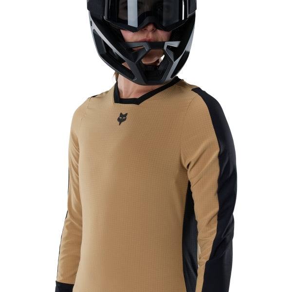 Fox Racing Defend Thermal Jersey (MTB) (Womens) in Brown Sugar, modeled front three-quarter view, with the crew neck, long sleeves, contrasting shoulder and arm graphics, and extended rear hem on a rider. Available options—Color: Brown Sugar, Black; Size: XS, SM, MD, LG, XL. SKU 33787-614-M. UPC 198571109861.