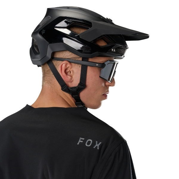 Fox Racing Flexair Water Pullover (MTB) in Black, modeled upper-body rear view, with the plain black back panel, long sleeves, small upper-back Fox lettering, and curved rear hem. Available options—Color: Black; Size: SM, MD, LG, XL, 2X.