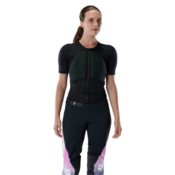 Fox Racing Baseframe Pro Short Sleeve (Womens) in Black, close-up of the interior fabric and pocket area, with the green perforated impact panel, black mesh stretch fabric, flat seams, and close-fitting cut on a rider. Available options—Color: Black; Size: SM, MD, LG.