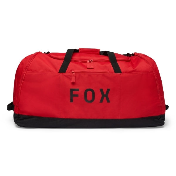 Fox Racing Podium Duffle in Blue Jewel, three-quarter view of the wheeled base and zippered compartments, with the main zippered compartment, reinforced base, carry handles, end pocket, wheels, and large Fox logo. Available options—Color: Black, Red, Blue Jewel.