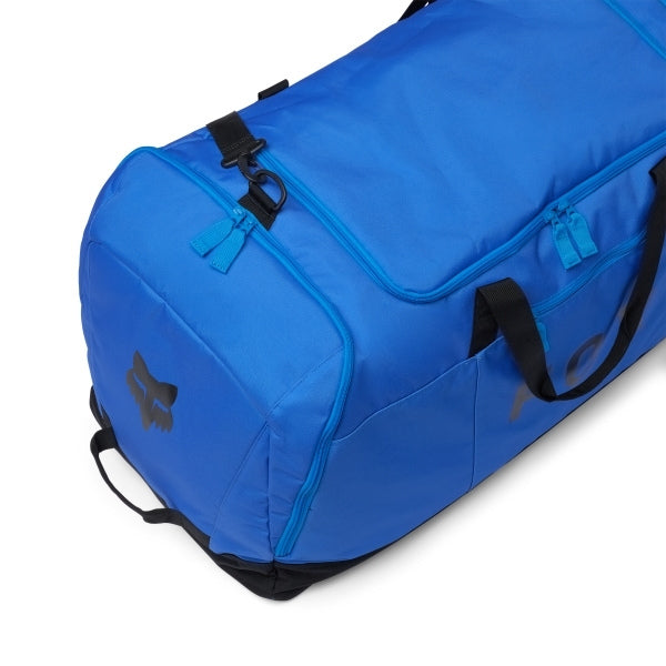 Fox Racing Podium Duffle in Blue Jewel, long-side view, with the main zippered compartment, reinforced base, carry handles, end pocket, wheels, and large Fox logo. Available options—Color: Black, Red, Blue Jewel.