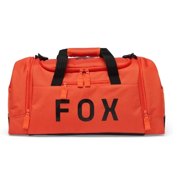 Fox Racing 180 Duffle in Orange, three-quarter view of the wheeled base and zippered compartments, with the main zippered compartment, reinforced base, carry handles, end pocket, wheels, and large Fox logo. Available options—Color: Black, Vivid Green, Orange.