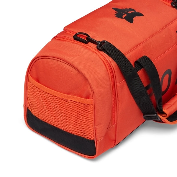 Fox Racing 180 Duffle in Orange, opposite long-side view, with the main zippered compartment, reinforced base, carry handles, end pocket, wheels, and large Fox logo. Available options—Color: Black, Vivid Green, Orange. - alternate view