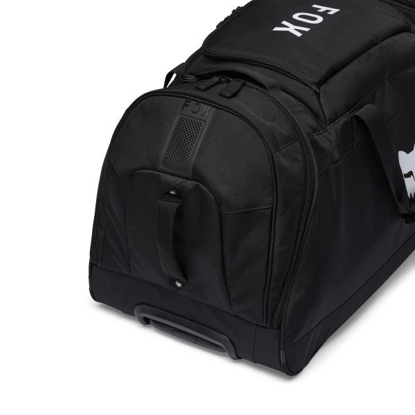 Fox Racing Shuttle Roller Bag in Midnight, opposite long-side view, with the main zippered compartment, reinforced base, carry handles, end pocket, wheels, and large Fox logo. Available options—Color: Black, Pewter, Midnight.