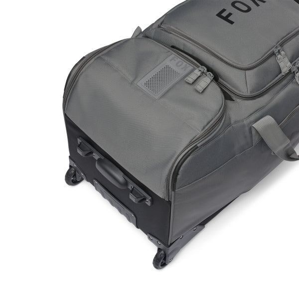 Fox Racing Shuttle Roller Bag in Midnight, long-side view, with the main zippered compartment, reinforced base, carry handles, end pocket, wheels, and large Fox logo. Available options—Color: Black, Pewter, Midnight.