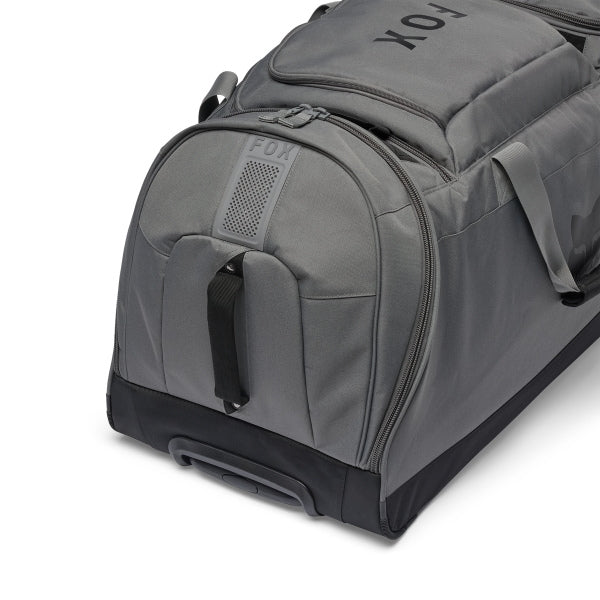 Fox Racing Shuttle Roller Bag in Midnight, opposite long-side view, with the main zippered compartment, reinforced base, carry handles, end pocket, wheels, and large Fox logo. Available options—Color: Black, Pewter, Midnight.