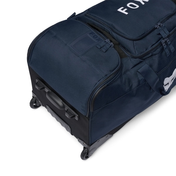 Fox Racing Shuttle Roller Bag in Midnight, long-side view, with the main zippered compartment, reinforced base, carry handles, end pocket, wheels, and large Fox logo. Available options—Color: Black, Pewter, Midnight.