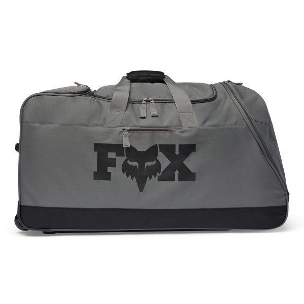 Fox Racing 180 Roller Bag in Midnight, three-quarter view of the wheeled base and zippered compartments, with the main zippered compartment, reinforced base, carry handles, end pocket, wheels, and large Fox logo. Available options—Color: Black, Pewter, Midnight.
