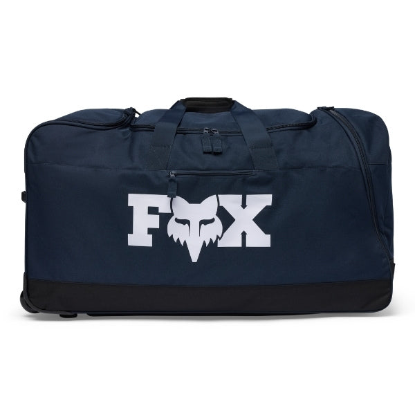Fox Racing 180 Roller Bag in Midnight, three-quarter view of the wheeled base and zippered compartments, with the main zippered compartment, reinforced base, carry handles, end pocket, wheels, and large Fox logo. Available options—Color: Black, Pewter, Midnight.