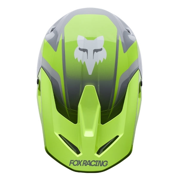 Fox Racing V1 Frame Helmet in Grey/Yellow, top view, with the visor tip, crown vents, shell graphics, and central Fox logo. Available options—Color: Black, Blue, Grey/Yellow, Neon Pink, Red; Size: XS, SM, MD, LG, XL, 2X. SKU 40615-086-XL. UPC 198571125939.