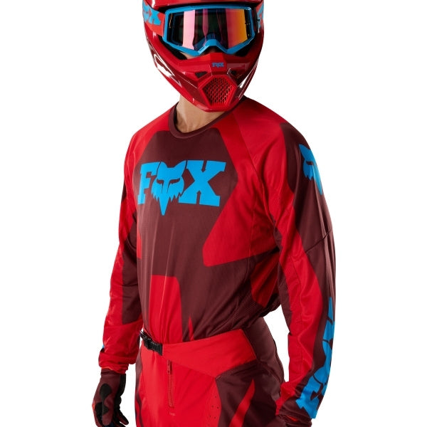 Fox Racing 180 Raid Jersey in Rust, modeled front three-quarter view, with the crew neck, long sleeves, contrasting shoulder and arm graphics, and extended rear hem on a rider. Available options—Color: Rust, Purple Lava, Deep Fern; Size: XS, SM, MD, LG, XL, 2X. SKU 40655-180-M. UPC 198571130858.