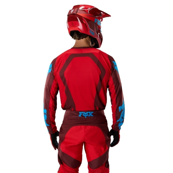 Fox Racing 180 Raid Jersey in Rust, close-up of the lower hem and drop-tail panel, with the printed Fox artwork, mesh-knit texture, reinforced seam lines, and shaped cuff or hem. Available options—Color: Rust, Purple Lava, Deep Fern; Size: XS, SM, MD, LG, XL, 2X. SKU 40655-180-2X. UPC 198571130889.