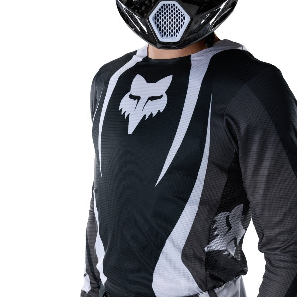 Fox Racing Flexair Thorn Jersey in Black/White, modeled front three-quarter view, with the crew neck, long sleeves, contrasting shoulder and arm graphics, and extended rear hem on a rider. Available options—Color: Black/White, Purple Lava, Red; Size: SM, MD, LG, XL, 2X. SKU 40658-018-L. UPC 198571123744.