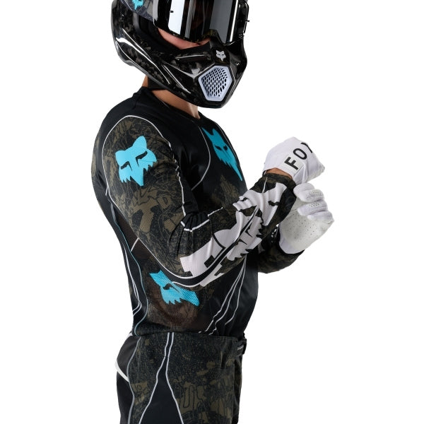 Fox Racing Flexair Apex Jersey in Black, close-up of the chest and shoulder panels, with the printed Fox artwork, mesh-knit texture, reinforced seam lines, and shaped cuff or hem. Available options—Color: Black; Size: SM, MD, LG, XL, 2X. SKU 40660-001-XL. UPC 198571133552.