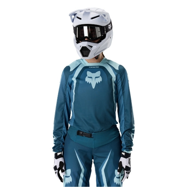 Fox Racing 180 Frame Jersey (Womens) in Deep Blue, close-up of the lower hem and drop-tail panel, with the printed Fox artwork, mesh-knit texture, reinforced seam lines, and shaped cuff or hem. Available options—Color: Neon Pink, Deep Blue; Size: XS, SM, MD, LG, XL.