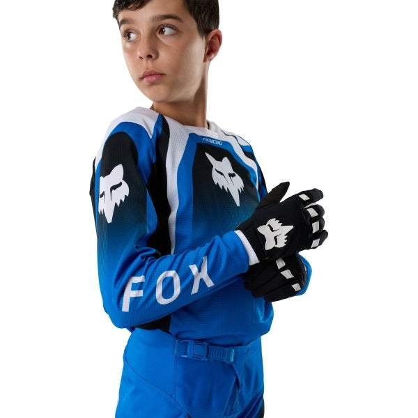 Fox Racing 180 Frame Jersey (Youth) in Blue, modeled front three-quarter view, with the crew neck, long sleeves, contrasting shoulder and arm graphics, and extended rear hem on a rider. Available options—Color: Blue, Grey/Yellow, Black, Red; Size: Y-SM, Y-MD, Y-LG, Y-XL. SKU 40672-002-YL. UPC 198571124093.