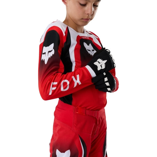 Fox Racing 180 Frame Jersey (Youth) in Red, close-up of the lower hem and drop-tail panel, with the printed Fox artwork, mesh-knit texture, reinforced seam lines, and shaped cuff or hem. Available options—Color: Blue, Grey/Yellow, Black, Red; Size: Y-SM, Y-MD, Y-LG, Y-XL.
