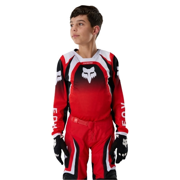 Fox Racing 180 Frame Jersey (Youth) in Red, full modeled front view, with the crew neck, long sleeves, contrasting shoulder and arm graphics, and extended rear hem on a rider. Available options—Color: Blue, Grey/Yellow, Black, Red; Size: Y-SM, Y-MD, Y-LG, Y-XL.