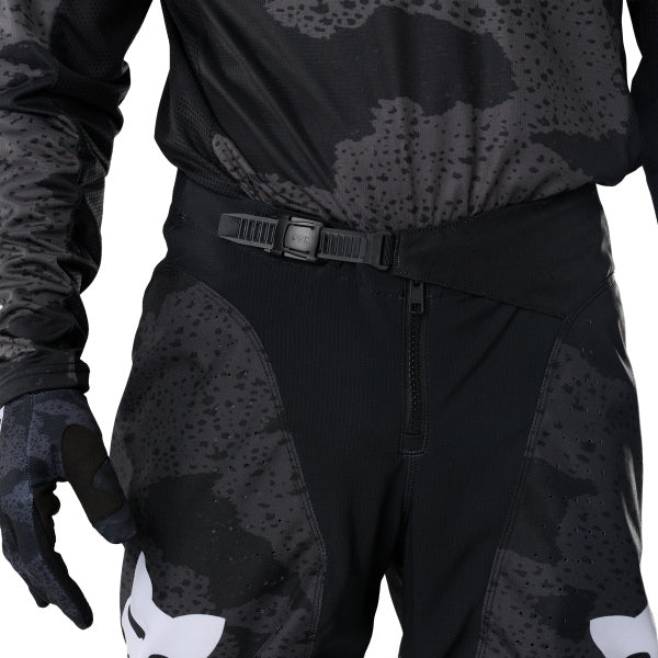 Fox Racing 180 BNKR Pants in Black Camo, close-up of the waist and hip panels, with the ratcheting waist adjuster, stretch yoke, shaped hip panel, and reinforced knee or thigh material. Available options—Color: Black Camo; Size: 26, 28, 30, 32, 34, 36, 38. SKU 40694-247-30. UPC 198571133668.