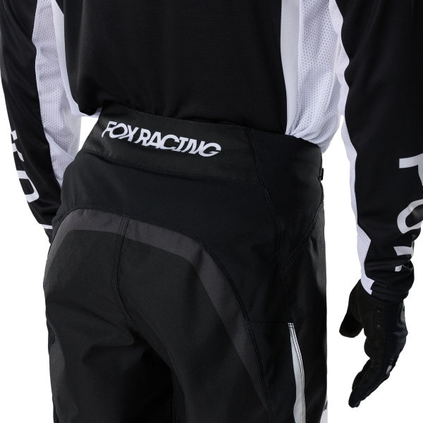 Fox Racing 180 Frame Pants in Black, rear product view, with the reinforced seat, rear yoke, articulated knees, tapered legs, and lower-leg graphics. Available options—Color: Blue, Grey/Yellow, Black, Red; Size: 26, 28, 30, 32, 34, 36, 38, 40, 42, 44. SKU 40696-001-28. UPC 198571122105.