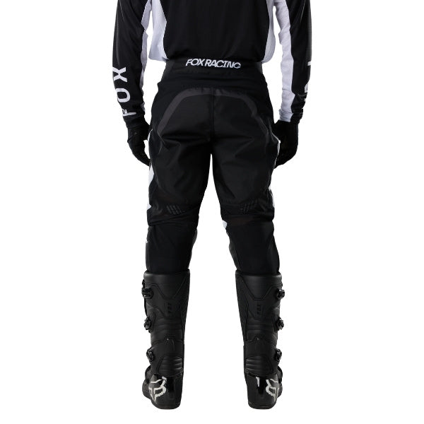 Fox Racing 180 Frame Pants in Black, close-up of the ratcheting waist closure, with the ratcheting waist adjuster, stretch yoke, shaped hip panel, and reinforced knee or thigh material. Available options—Color: Blue, Grey/Yellow, Black, Red; Size: 26, 28, 30, 32, 34, 36, 38, 40, 42, 44. SKU 40696-001-32. UPC 198571122129.