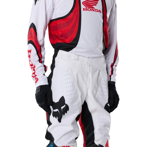 Fox Racing 180 Honda Pants in White/Red, close-up of the waist and hip panels, with the ratcheting waist adjuster, stretch yoke, shaped hip panel, and reinforced knee or thigh material. Available options—Color: White/Red; Size: 26, 28, 30, 32, 34, 36, 38. SKU 40708-077-30. UPC 198571132791.