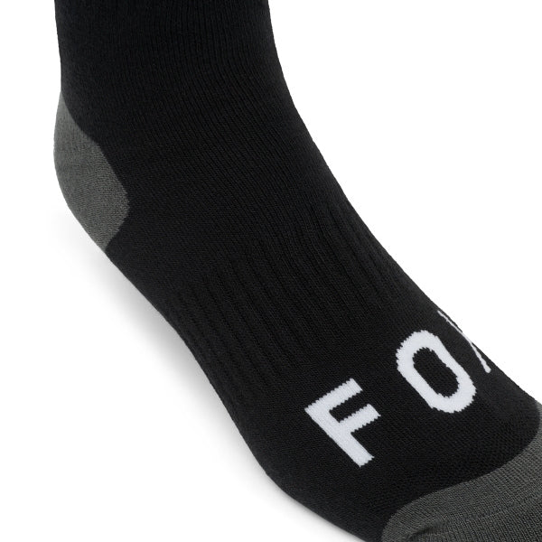 Fox Racing 180 Elevated Core Socks in Black, close-up of the ribbed foot and toe, with the ribbed cuff, knitted Fox graphics, shaped heel, reinforced toe, and ventilated stretch knit. Available options—Color: Black, Midnight, Red, Grey; Size: SM, MD, LG. SKU 40716-001-L. UPC 198571122464.