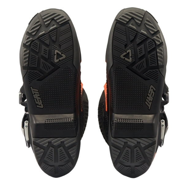 Leatt Moto 5.5 FlexLock Enduro Evo boots in Black/Orange, bottom view showing the tread pattern on both soles