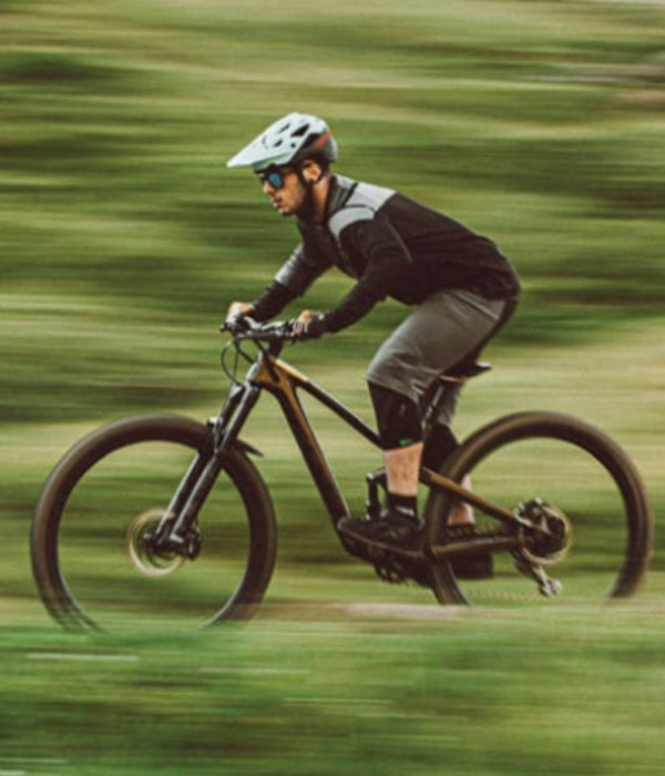 Person riding a bicycle on a blurred green background O'Neal collection