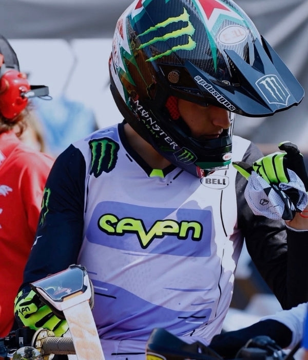Person wearing a motocross helmet and gear with visible branding Seven MX collection