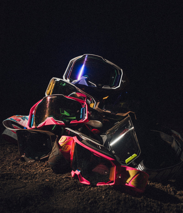 Stack of colorful goggles on a dark background 100% Goggles collection
