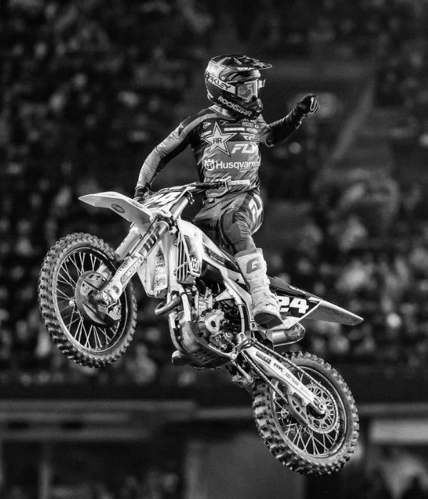 Black and white photo of motocross rider mid-air performing a jump in a stadium collection