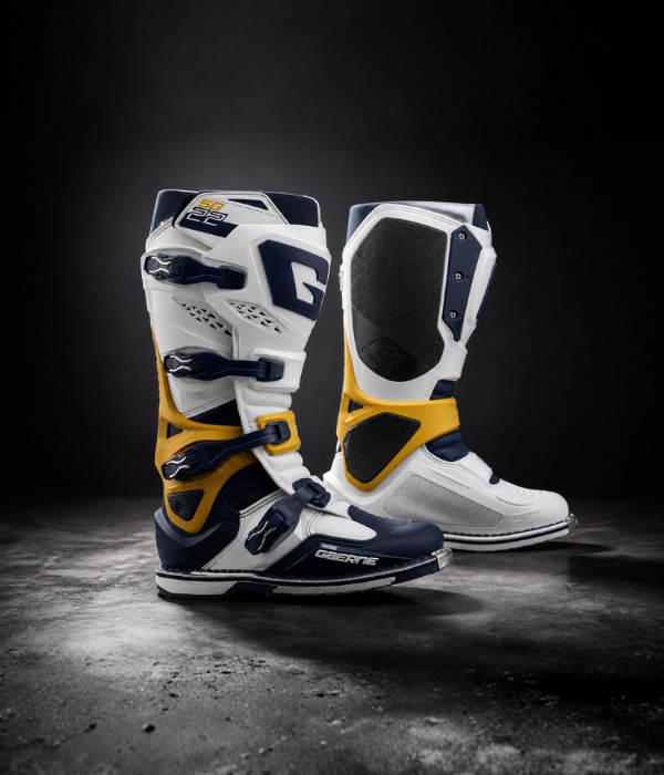 Gaerne SG22 motocross boots in white, navy, and yellow shown in a clean studio with directional lighting collection