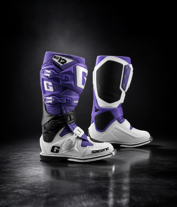 Gaerne SG12 LE motocross boots in purple and white displayed on a glossy studio floor with soft spotlight collection